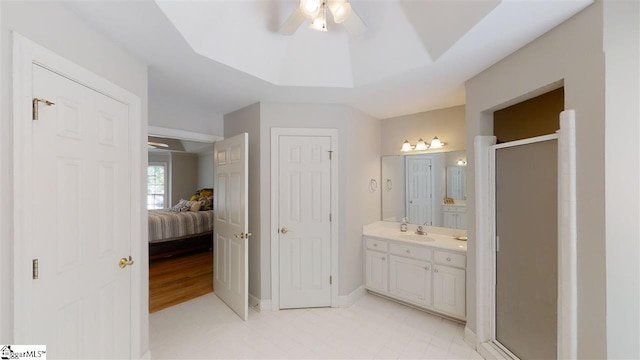 bathroom with a shower with shower door, tile floors, ceiling fan, and vanity