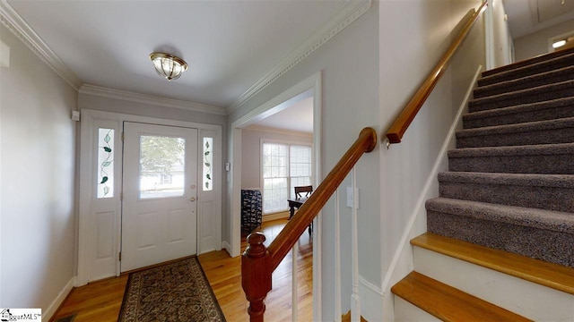 foyer entrance featuring crown molding and light hardwood / wood-style flooring