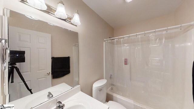 full bathroom with sink, shower / bath combo with shower curtain, and toilet