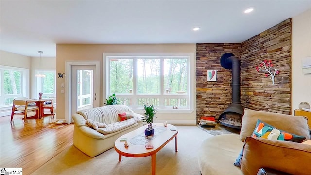 living room featuring a wood stove, light hardwood / wood-style floors, and plenty of natural light