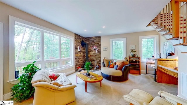 interior space with a healthy amount of sunlight, a wood stove, and light colored carpet