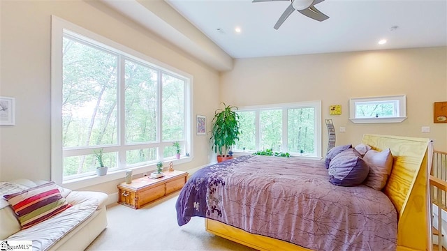 carpeted bedroom featuring lofted ceiling, multiple windows, and ceiling fan