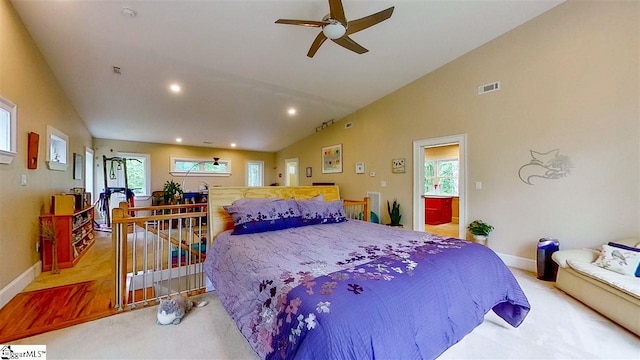 bedroom featuring light carpet, multiple windows, ceiling fan, and vaulted ceiling