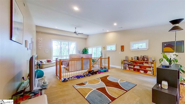 recreation room featuring light carpet and ceiling fan