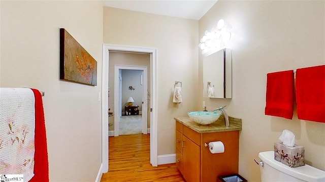 bathroom featuring toilet, hardwood / wood-style floors, and vanity