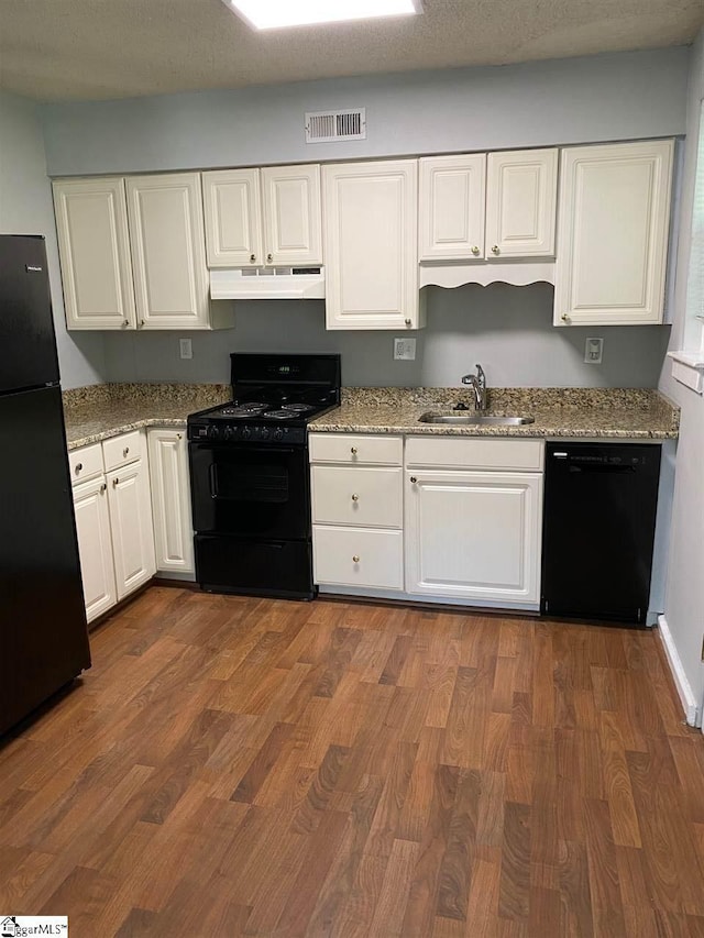 kitchen with white cabinets, sink, black appliances, and hardwood / wood-style floors