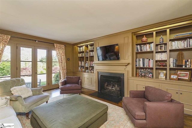 living room with built in features, light wood-type flooring, and french doors