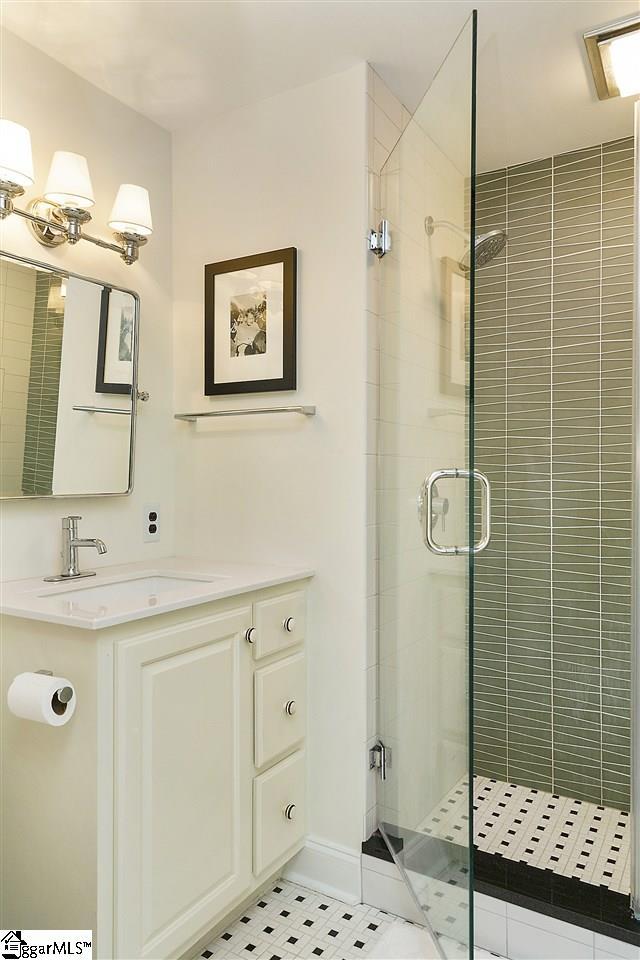 bathroom featuring an enclosed shower, vanity, and tile floors