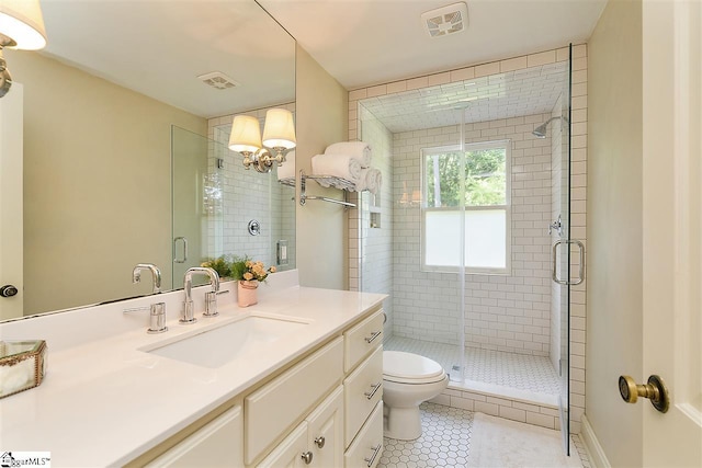 bathroom with toilet, tile flooring, a shower with shower door, and vanity