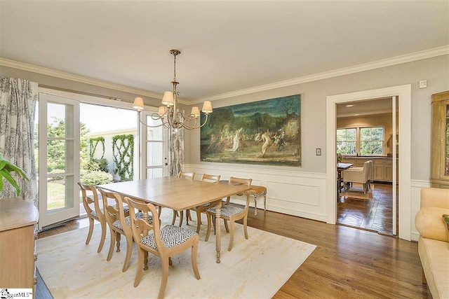 dining room featuring a notable chandelier, dark wood-type flooring, and ornamental molding