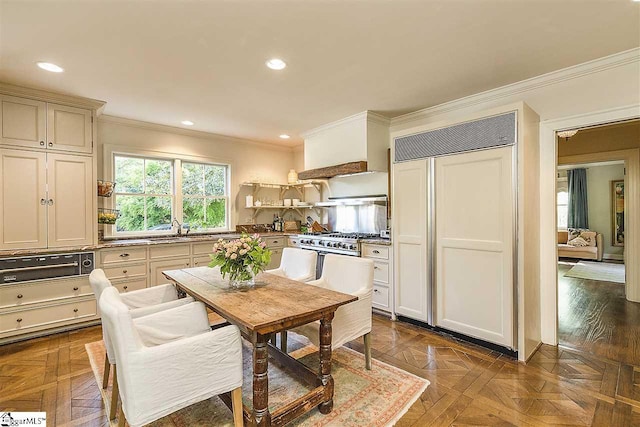 dining space with crown molding, dark parquet floors, and sink