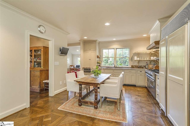 kitchen with premium appliances, custom exhaust hood, sink, dark parquet flooring, and ornamental molding