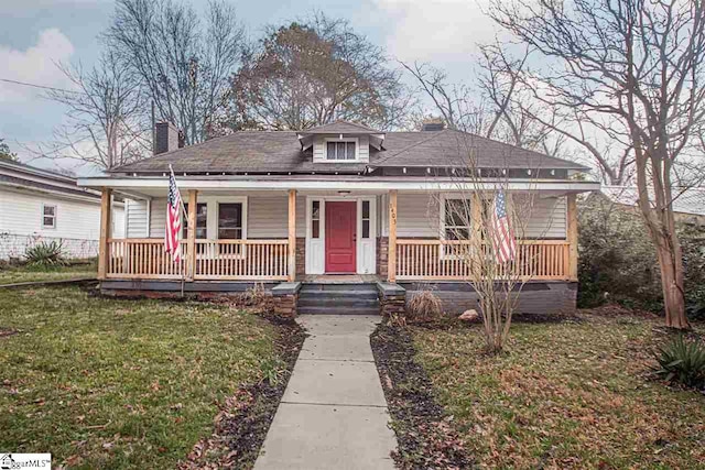 bungalow-style home with covered porch and a front yard