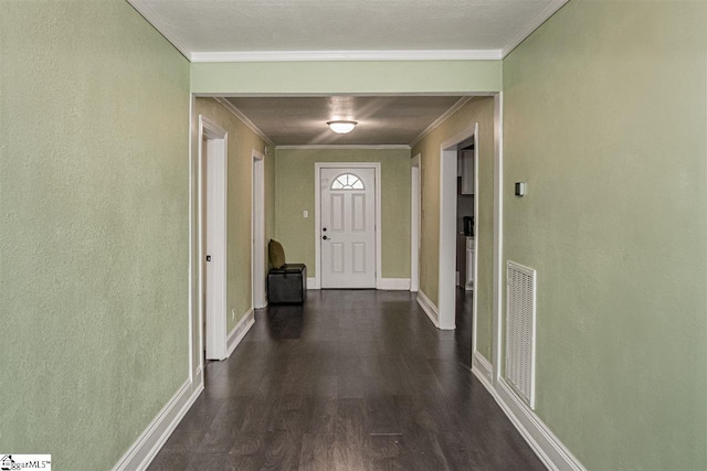 corridor featuring a textured ceiling, dark wood-type flooring, and ornamental molding