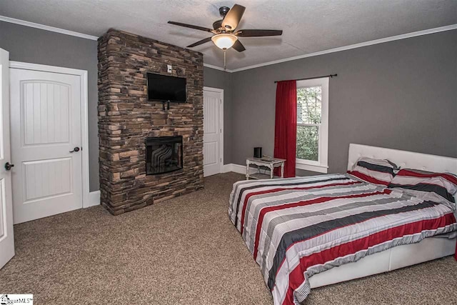 bedroom featuring a stone fireplace, crown molding, ceiling fan, a textured ceiling, and dark carpet