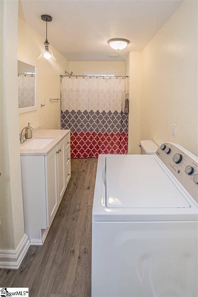 laundry room featuring washer / clothes dryer, dark wood-type flooring, and sink