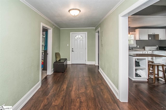 entrance foyer featuring dark hardwood / wood-style flooring, ornamental molding, and sink