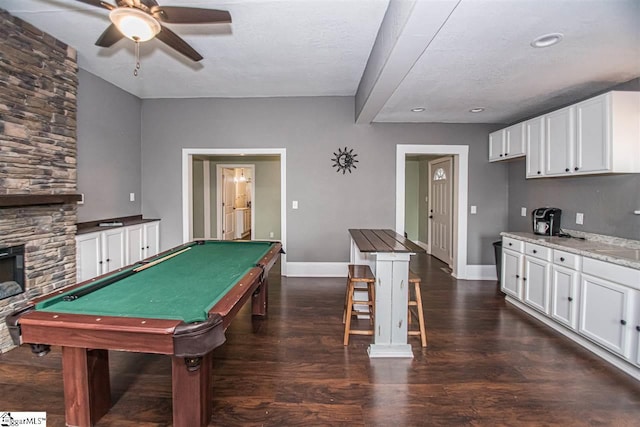 playroom featuring ceiling fan, a fireplace, a textured ceiling, pool table, and dark hardwood / wood-style floors