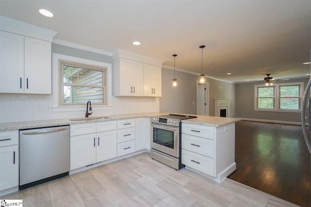 kitchen featuring plenty of natural light, ceiling fan, white cabinetry, appliances with stainless steel finishes, and sink