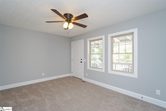 carpeted spare room with ceiling fan