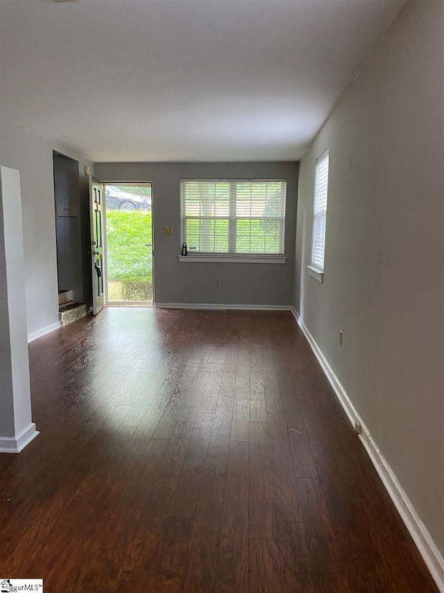 spare room featuring dark hardwood / wood-style flooring and a healthy amount of sunlight