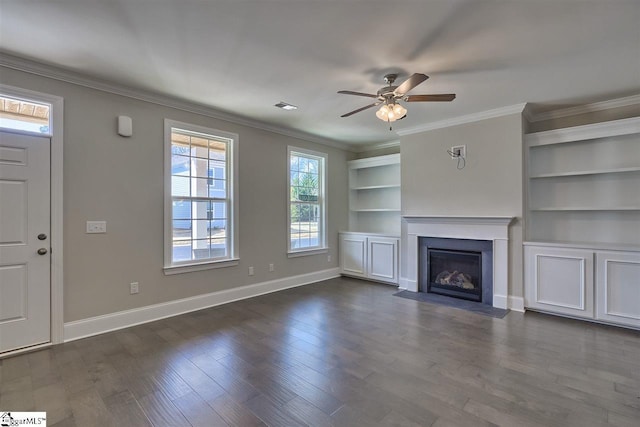 unfurnished living room featuring ceiling fan, built in shelves, ornamental molding, and dark hardwood / wood-style flooring