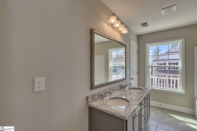 bathroom featuring dual sinks, oversized vanity, a wealth of natural light, and tile floors