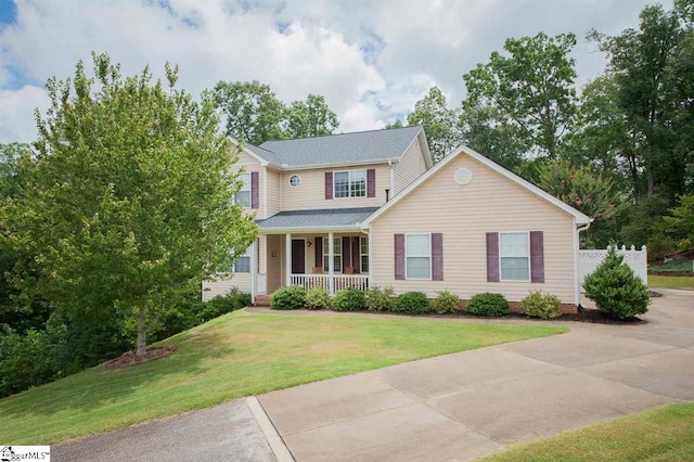 view of front of home with covered porch and a front lawn