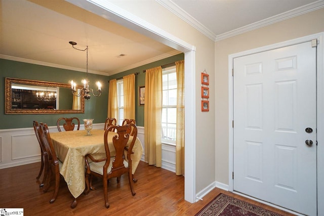 dining area with a notable chandelier, dark hardwood / wood-style flooring, and ornamental molding