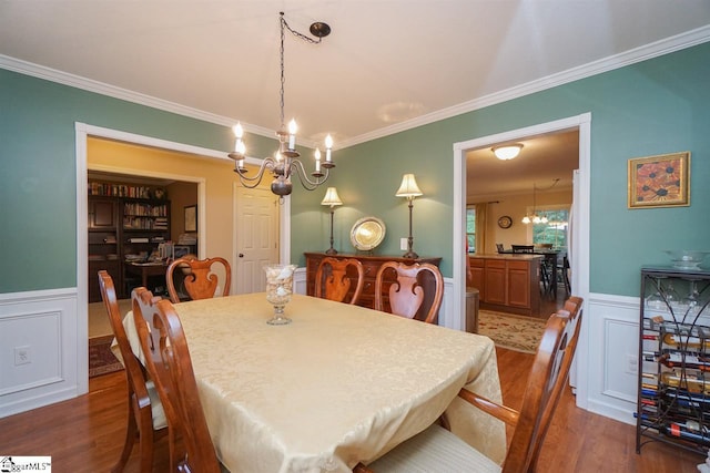 dining space featuring an inviting chandelier, dark wood-type flooring, and ornamental molding