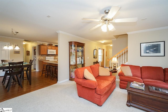 carpeted living room with crown molding and ceiling fan with notable chandelier