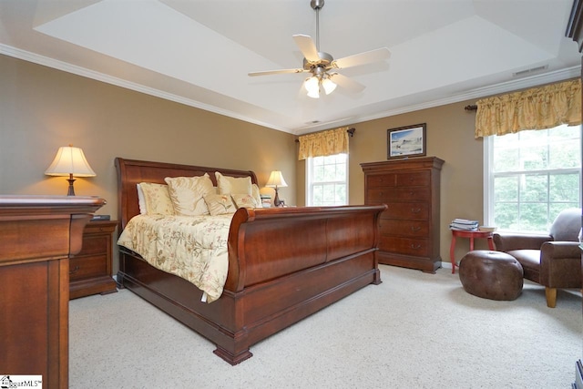 carpeted bedroom with a raised ceiling, ceiling fan, and crown molding