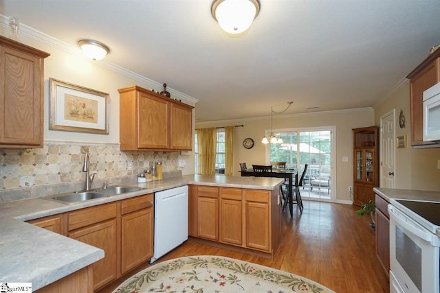 kitchen featuring light hardwood / wood-style floors, a notable chandelier, kitchen peninsula, white appliances, and sink