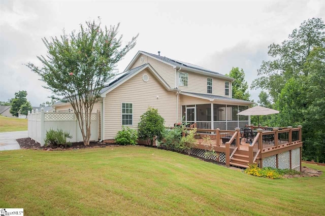 back of property with a deck and a lawn