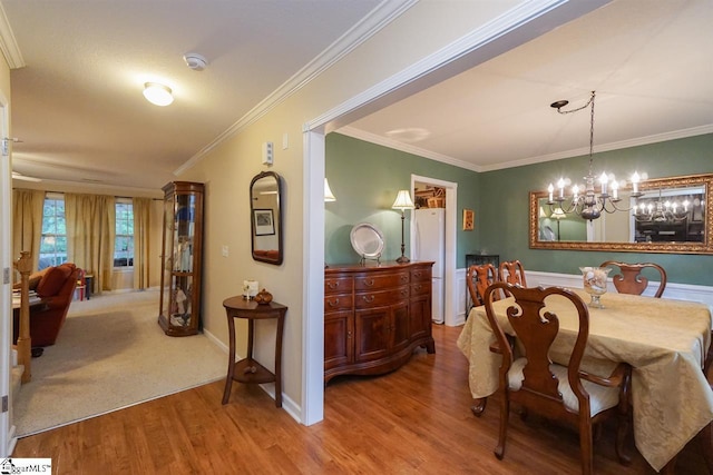 dining area with ornamental molding, a chandelier, and hardwood / wood-style flooring