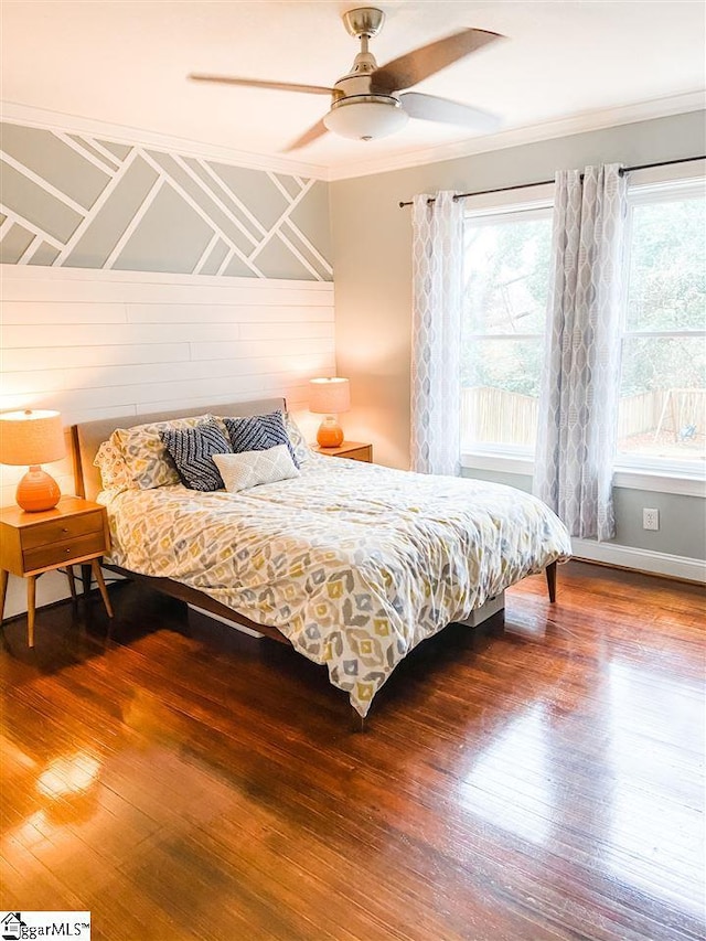 bedroom featuring dark hardwood / wood-style flooring, ceiling fan, and ornamental molding