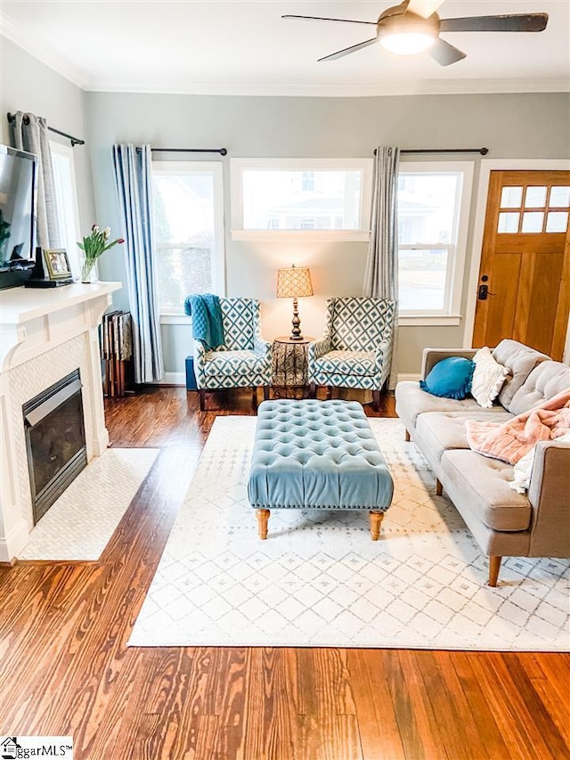 living room featuring hardwood / wood-style floors, ceiling fan, and crown molding