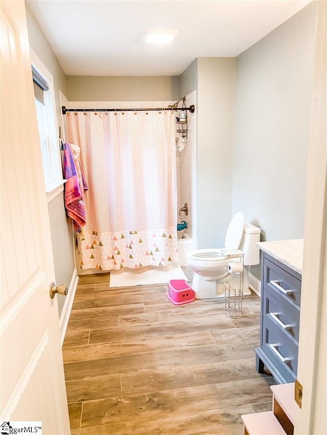 full bathroom with vanity, hardwood / wood-style floors, toilet, and shower / bathtub combination with curtain