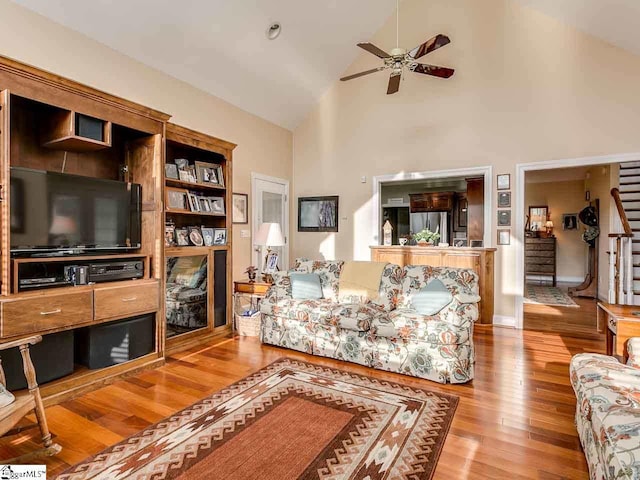 living room featuring high vaulted ceiling, ceiling fan, and light hardwood / wood-style flooring