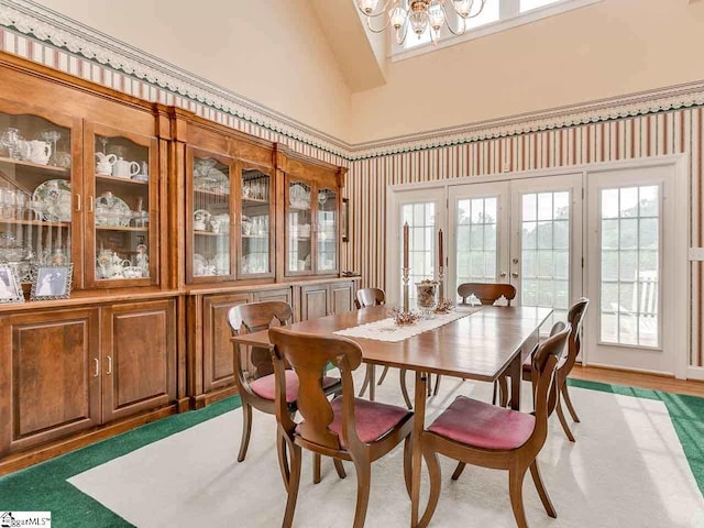 dining space with high vaulted ceiling, french doors, and a notable chandelier