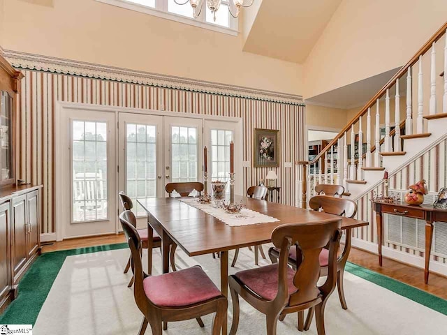 dining area with a notable chandelier, high vaulted ceiling, dark wood-type flooring, and french doors