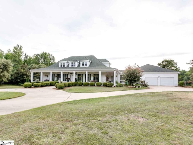 view of front of property featuring a porch, a front yard, and a garage