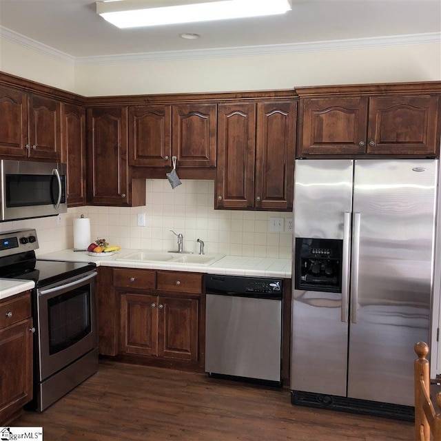 kitchen featuring sink, appliances with stainless steel finishes, backsplash, and dark hardwood / wood-style flooring