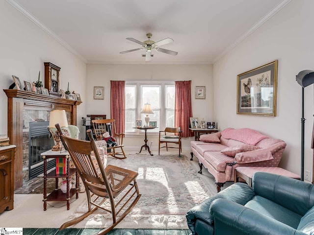 carpeted living room with crown molding, ceiling fan, and a fireplace