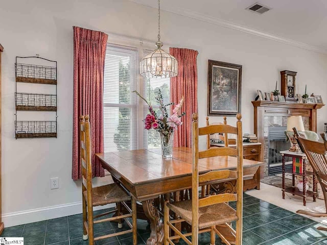 tiled dining room with a notable chandelier and crown molding