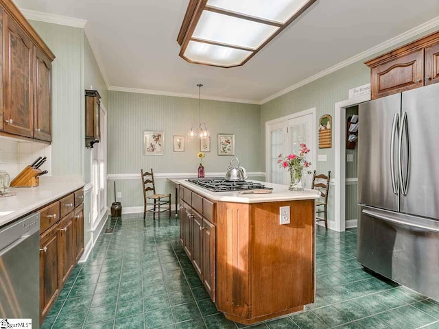 kitchen featuring dark tile floors, a kitchen island, hanging light fixtures, appliances with stainless steel finishes, and a chandelier