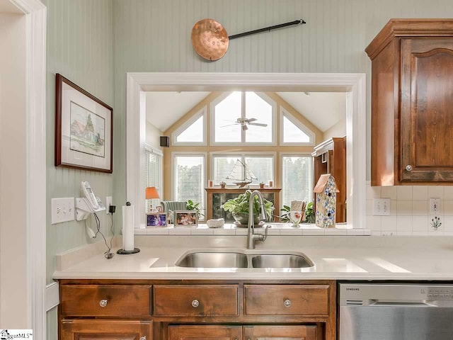 kitchen with ceiling fan, sink, stainless steel dishwasher, vaulted ceiling, and tasteful backsplash