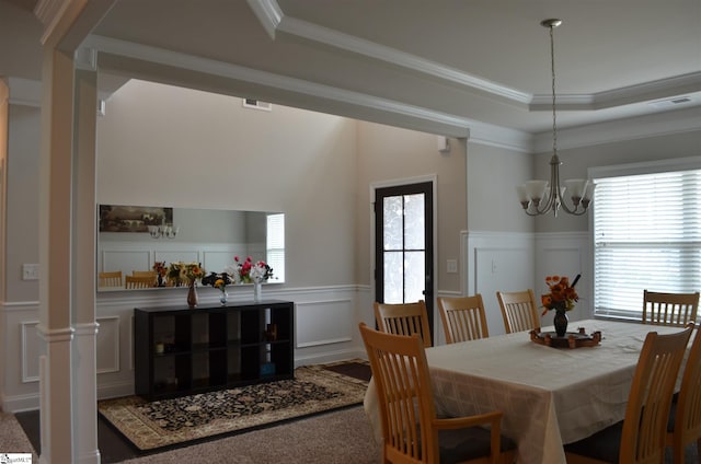 dining area with a tray ceiling, ornamental molding, and a notable chandelier