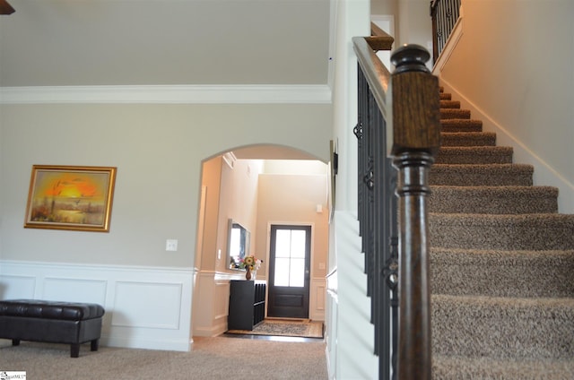 stairs with light carpet and crown molding