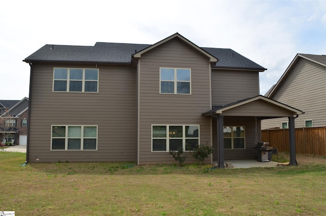 rear view of property featuring a lawn and a patio area